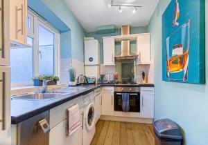 a kitchen with a sink and a washing machine at Dorset Green Two By My Getaways in Brighton & Hove