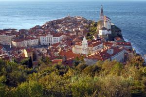 an aerial view of a town on a hill next to the ocean at New Listing 2023 - Warm and Comfy Piran Apartment with Parking! in Piran