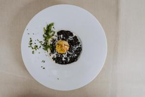 a white plate with an egg on top of it at Hotel Bergschlössl in Luson