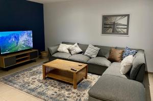 a living room with a couch and a tv at Moringa Gardens Self Catering Apartments in Swakopmund