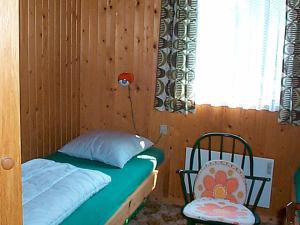 a bedroom with a bed and a chair and a window at 5 person holiday home in B rkop in Egeskov