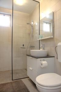 een badkamer met toilet, wastafel en douche bij Warm and Comfy Piran Apartment with Parking! in Piran +17 foto's
