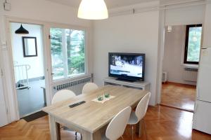 een eetkamer met een houten tafel en een televisie bij New Listing 2023 - Warm and Comfy Piran Apartment with Parking! in Piran