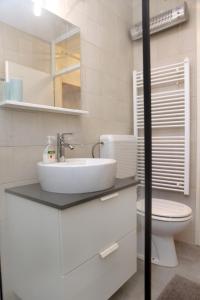 een witte badkamer met een wastafel en een toilet bij New Listing 2023 - Warm and Comfy Piran Apartment with Parking! in Piran