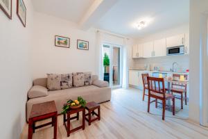 a living room with a couch and a table and a kitchen at Holiday Home Iva in Mlini