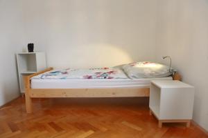 een bed in een kamer met een witte muur bij Warm and Comfy Piran Apartment with Parking! in Piran