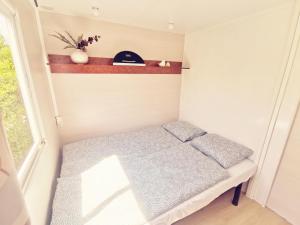 uma pequena cama num pequeno quarto com uma janela em Casa Azul-Tiny house with fantastic view, big outdoor space and pool em Silves