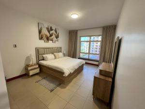 a bedroom with a bed and a large window at شقق فخامة المارينا Grandeur Marina Apartments in King Abdullah Economic City