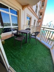 eine Terrasse mit einem Tisch und Stühlen auf dem Balkon in der Unterkunft شقق فخامة المارينا Grandeur Marina Apartments in King Abdullah Economic City