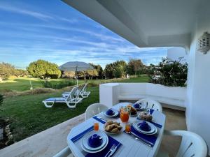 een witte tafel met borden eten op een patio bij Albufeira Balaia Golf Village 1 With Pool by Homing in Albufeira