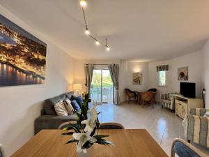 een woonkamer met een tafel en een bank bij Albufeira Balaia Golf Village 1 With Pool by Homing in Albufeira