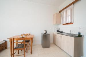 a kitchen with a table and a sink and a refrigerator at Myrtos View Apartments in Anomeriá