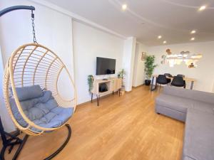 a living room with a hanging chair and a couch at Central Station Apartment in Setúbal