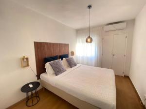 Un dormitorio con una gran cama blanca y una mesa en Central Station Apartment en Setúbal