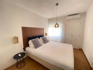 um quarto com uma grande cama branca e uma mesa em Central Station Apartment em Setúbal