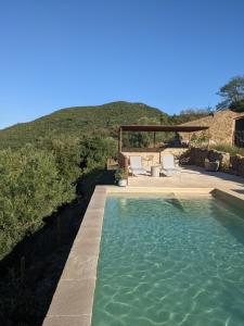 a swimming pool in front of a hill at Mas Oms in Montnegre