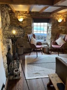 una sala de estar con 2 sillas y una lámpara. en Lavender Cottage en Newquay