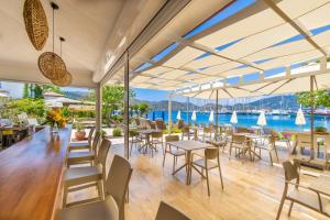 a restaurant with tables and chairs and a view of the water at selimiye base in Marmaris