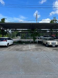 dois carros estacionados num parque de estacionamento em โรงแรมช้างใหญ่ใจดี em Yasothon