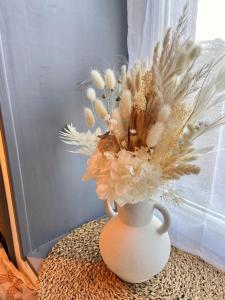 um vaso branco com flores sobre uma mesa em Studio Coquet proche Gare em Bourg-en-Bresse