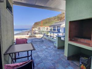 a balcony with a table and a view of the beach at On the Wave by LovelyStay in Paul do Mar