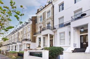 una fila di case bianche su una strada di Bright one bedroom apartment with balcony in Maida Vale by UnderTheDoormat a Londra