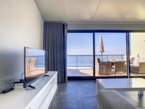 uma sala de estar com televisão e vista para o oceano em On the Wave by LovelyStay em Paul do Mar