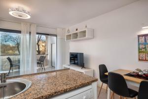 cocina con fregadero y mesa con sillas en Hauzify I Apartament Port Mar, en Platja d'Aro