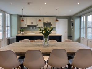 a kitchen and dining room with a large wooden table and chairs at Converted Victorian Coach House with Hot Tub in Stewartstown