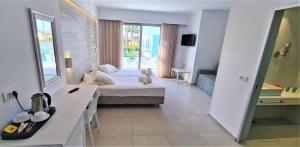 um quarto com uma cama e uma mesa num quarto em Apollon Windmill Boutique Hotel - Adults Only em Cidade de Kos