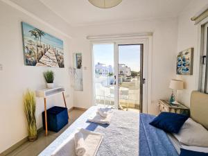 a bedroom with a bed and a window with a view at Nissi beach villa Oleandra in Ayia Napa +41 photos