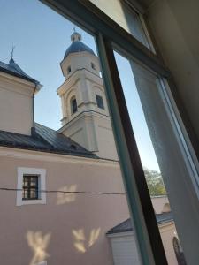 una finestra con vista su un edificio con torre dell'orologio. di 25 Hours Hostel a Vilnius