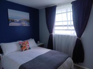 Schlafzimmer mit einem Bett und einem Fenster in der Unterkunft ikhay'olwandle in East London