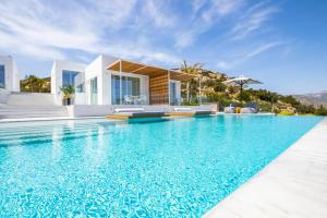 a villa with a swimming pool in front of a house at ISTIA LUXURY VILLAS in Karpathos Town