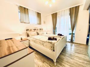 ein Schlafzimmer mit einem weißen Bett und einem großen Fenster in der Unterkunft Apartments in Complex Sunny Island Deluxe in Tschernomorez
