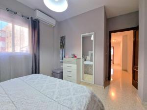 een slaapkamer met een bed, een dressoir en een spiegel bij Apartamento Alférez in Sanlúcar de Barrameda