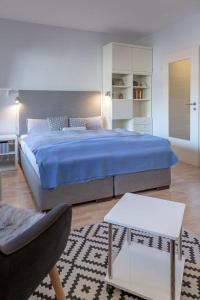 - une chambre avec un lit king-size et une chaise dans l'établissement App-Scholle-Haus-Ornum, à Westerland