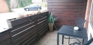 un patio avec un banc, une table et une voiture dans l'établissement App-Scholle-Haus-Ornum, à Westerland