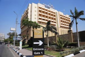 a building with an entrance sign in front of it at Triumph Plaza Hotel in Cairo