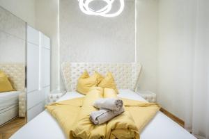 a bedroom with a large bed with a yellow blanket at Heart of Budapest Luxury Apartment with Amazing View in Budapest +69 photos