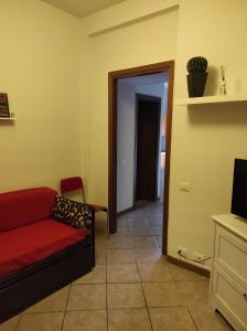 a living room with a red couch and a doorway at Casina di mezzo in Borgo a Buggiano