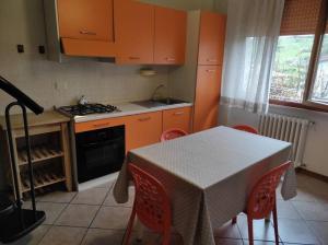 a kitchen with orange cabinets and a table with chairs at Casina di mezzo in Borgo a Buggiano