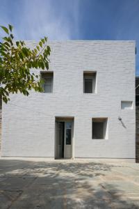 a white building with a door in front of it at house λ in Skiathos