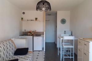 a living room with a couch and a kitchen at Studio Port du Cap d'Agde in Cap d'Agde