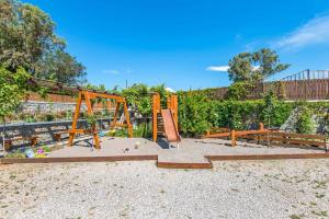 a playground with a swing set in a park at Villa Kiotari Ariti in Kiotari
