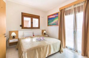 a bedroom with a bed and a large window at Villa Kiotari Ariti in Kiotari