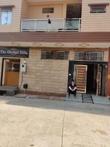 a man sitting in the doorway of a building at The Orchid Villa Homestay in Agra