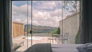a bedroom with a large window with a view of a patio at Pousada Monttana in Lavras Novas