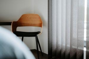 une chaise en bois assise à côté d'une fenêtre dans l'établissement B&B Koor91, à Hasselt