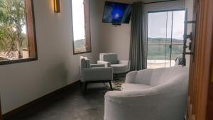 a waiting room with chairs and a couch and a window at Pousada Monttana in Lavras Novas